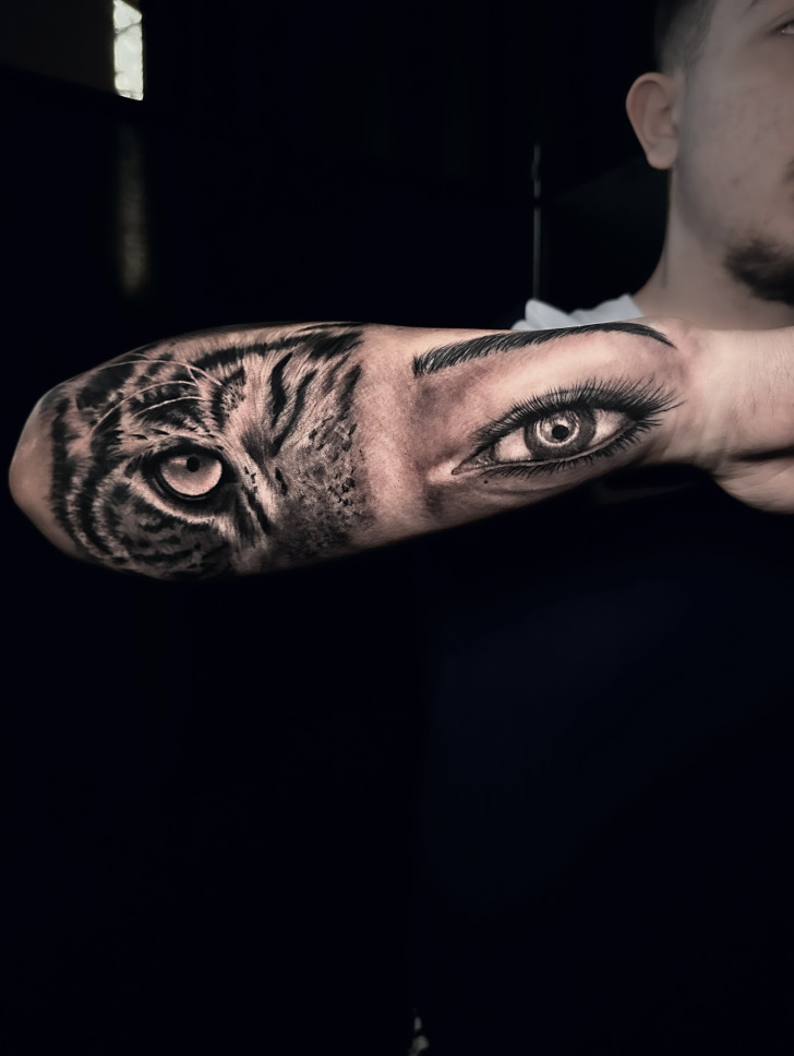 Surreal tattoo fusing a tiger eye with a human eye